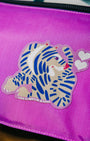 Purple bag with a Lisa Congdon tiger design patch and hearts on a pink background